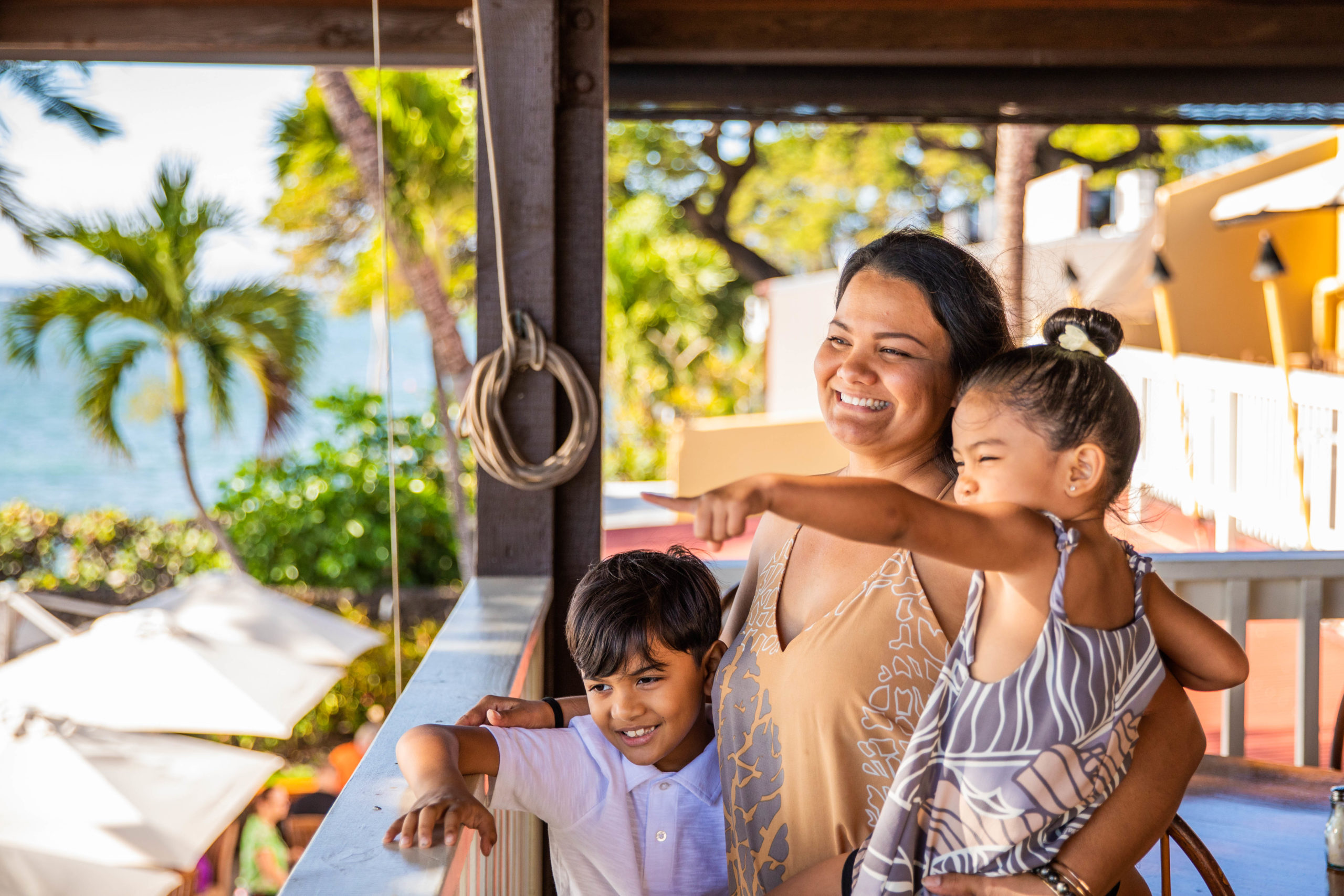 Mom and children stand in a restaurant and point to something in the distance